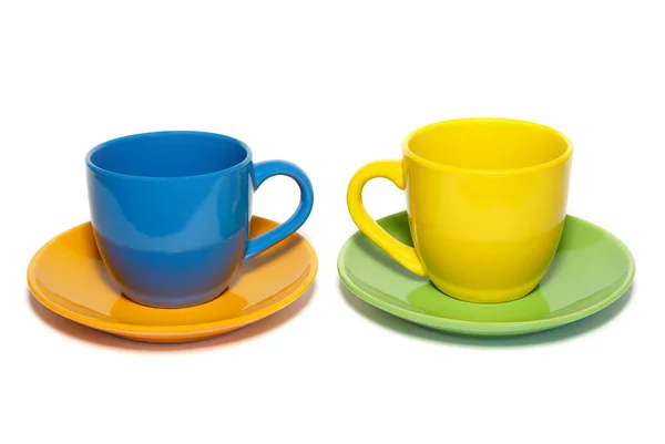 Farbige Teetassen und Untertassen isoliert auf weiß. — Stockfoto