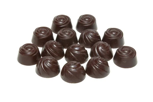 Deliciosas pralinas de chocolate escuro isoladas em branco . — Fotografia de Stock