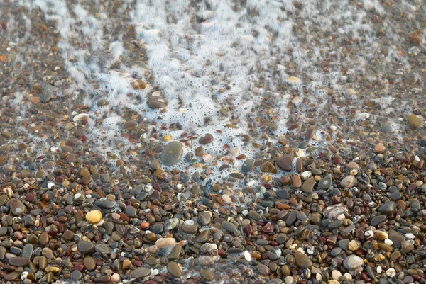 Wave, foam and textured stones. — Stock Photo, Image