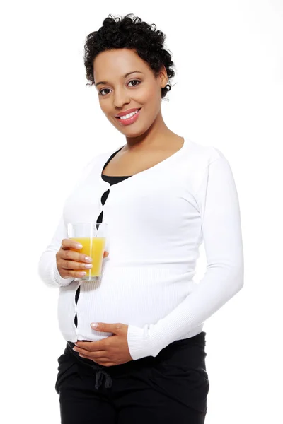 Mujer embarazada sosteniendo un vaso de jugo de naranja — Foto de Stock