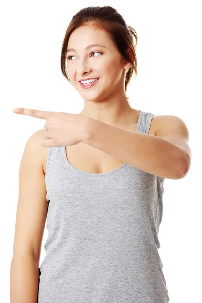 Young teen girl pointing on left — Stock Photo, Image