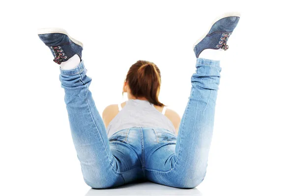 Visão traseira da menina adolescente deitada em sua barriga — Fotografia de Stock