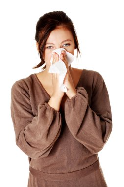 Young girl blowing her nose.