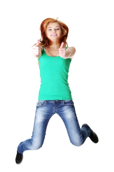 Молодая девушка прыгает и показывает нормальный жест — стоковое фото