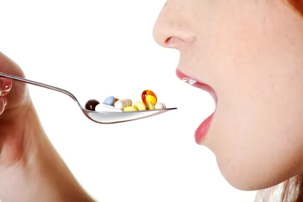 Крупный план во рту девушки, принимающей таблетки . — стоковое фото