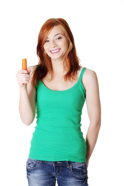 Teen standing girl holding a carrot. — Stock Photo, Image