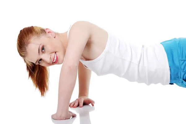 Teen girl doing exercises on the floor. — Stock Photo, Image
