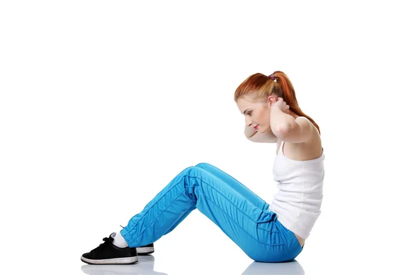 Студент-підліток виконує вправи на підлозі . — стокове фото