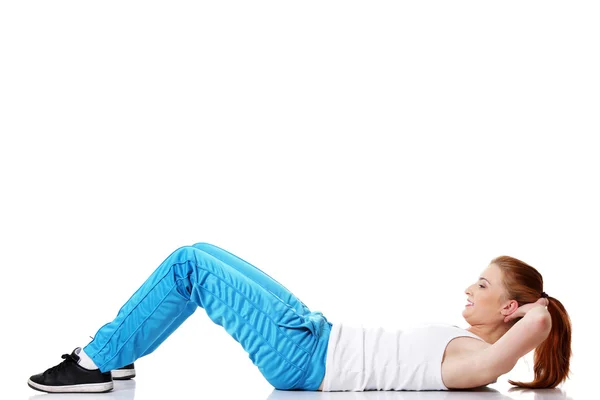 Adolescenta student face exerciții pe podea . — Fotografie, imagine de stoc