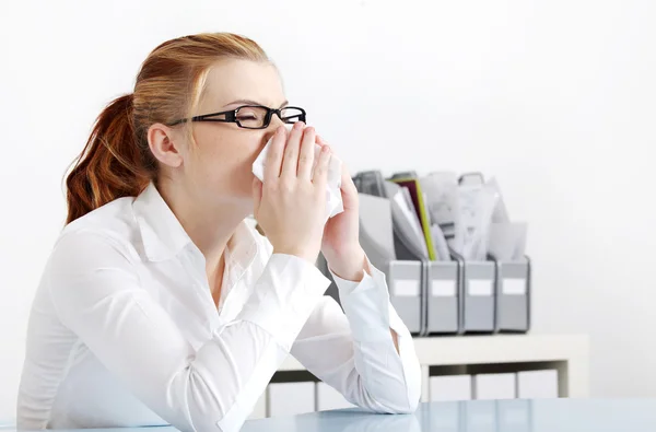 Sneezing woman in the office. — Stock Photo, Image