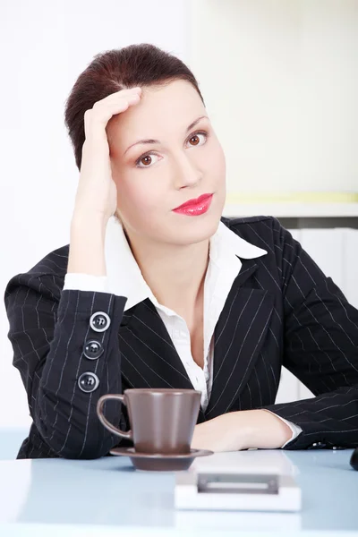 Denkende Geschäftsfrau sitzt im Büro. — Stockfoto