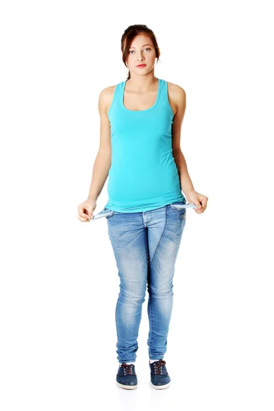 Mladá dospívající dívka stojící a ukazuje její prázdné kapsy. — Stock fotografie