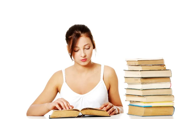 Ung flicka läsa nära högen av böcker. — Stockfoto
