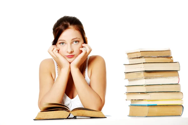 Jovencita sosteniendo la cabeza y sentada con libros . —  Fotos de Stock