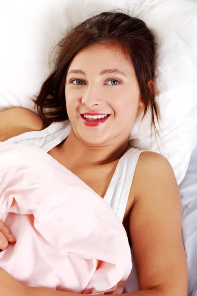 침대에 누워 웃는 소녀. — 스톡 사진