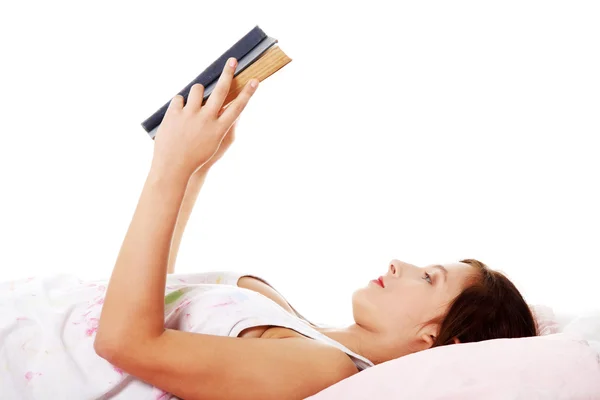 Dospívající dívka čtení v posteli. — Stock fotografie