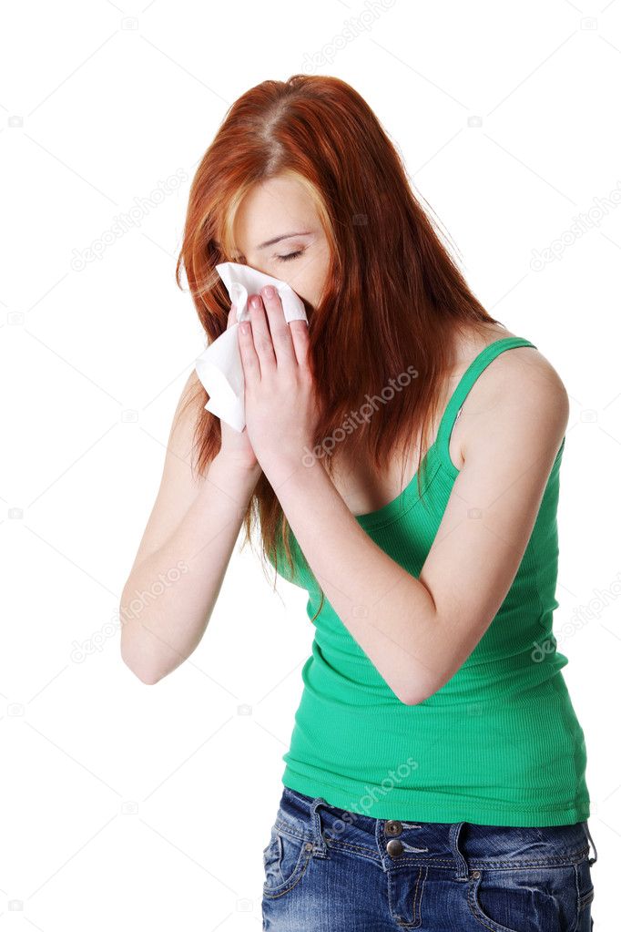 Teen girl blowing her nose.