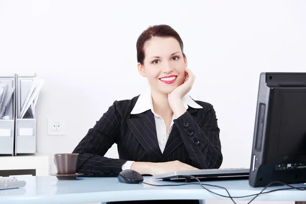 Glimlachende zakenvrouw zitten in het kantoor. — Stockfoto