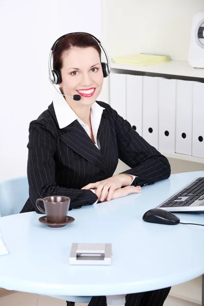 Biznes kobieta ze słuchawkami w biurze. — Zdjęcie stockowe