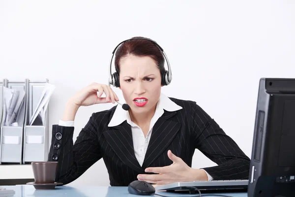 Mooie zakenvrouw schreeuwen via de hoofdtelefoon. — Stockfoto