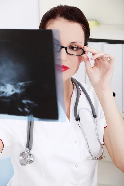 Vrouwelijke arts kijkt naar x-ray. — Stockfoto