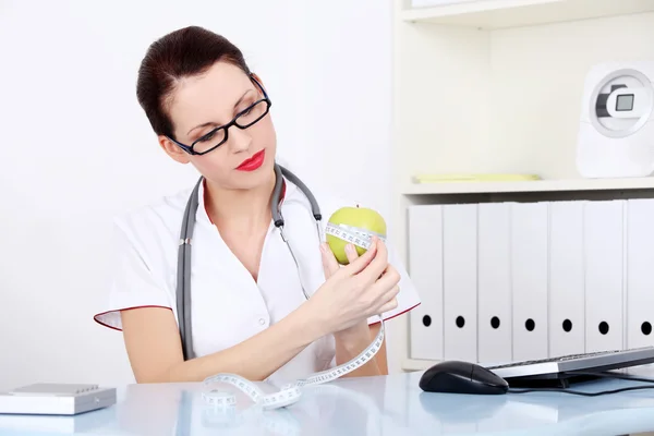 Женщина-врач, измеряющая яблоко . — стоковое фото