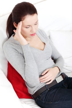 Suffering woman sitting on a sofa.