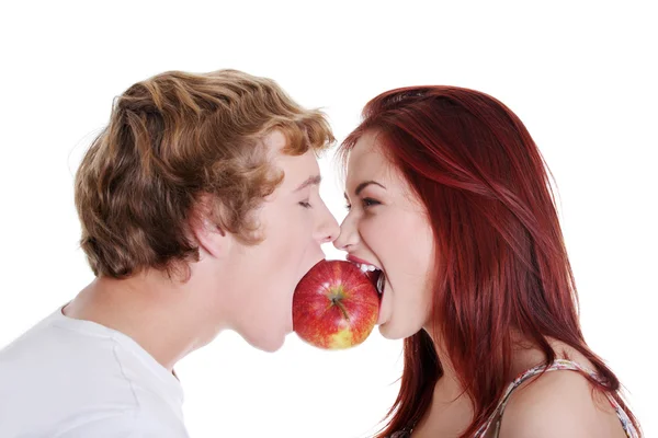 Paar beißt in einen Apfel. — Stockfoto