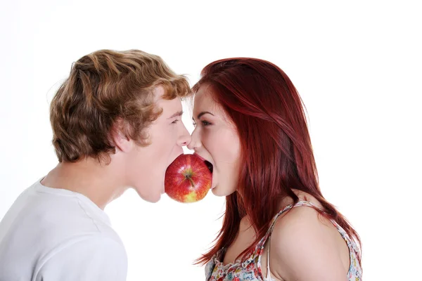 Paar beißt in einen Apfel. — Stockfoto