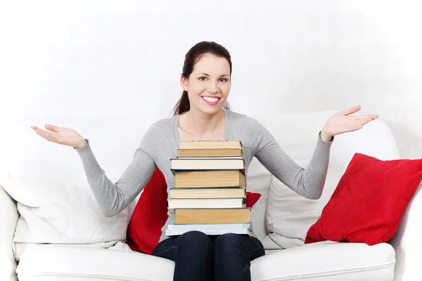 Kız öğrenci bir yığın kitap tutan gülümseyerek. — Stok fotoğraf