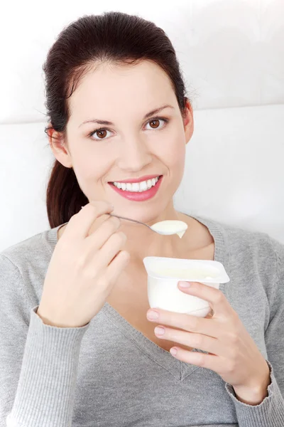 Mulher bonita comendo um iogurte em casa . — Fotografia de Stock