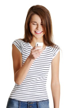 Happy caucasian teen with a mobile. clipart