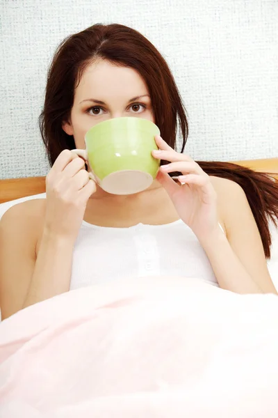 Frau trinkt morgens Kaffee im Bett. — Stockfoto