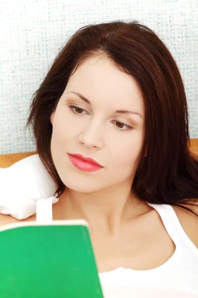 Mujer relajada leyendo un libro en la cama por la mañana . — Foto de Stock