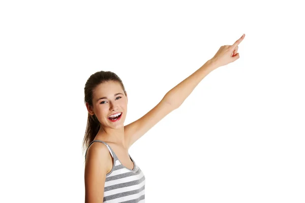 Mujer caucásica adolescente apuntando hacia arriba con un dedo . — Foto de Stock