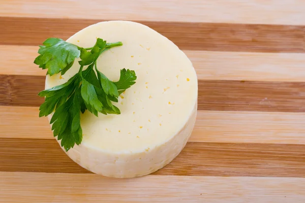 Круглый сыр на доске — стоковое фото