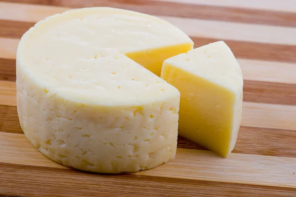 Runden Käse schneiden — Stockfoto