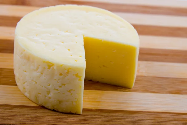 丸いチーズをカットします。 — ストック写真