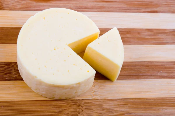 Kerek sajt egy fából készült hajón — Stock Fotó