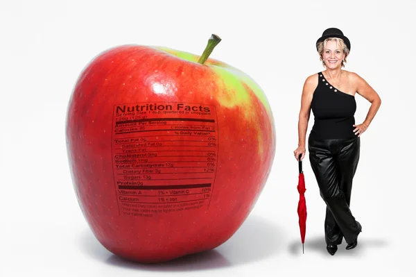 Mujer de mediana edad con manzana roja deliciosa con etiqueta nutricional —  Fotos de Stock