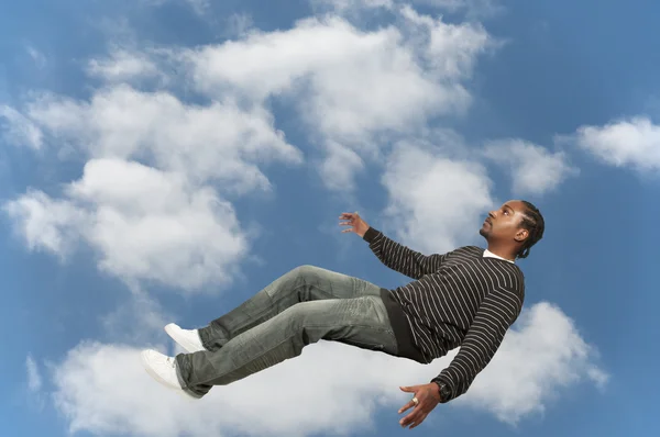 Homem negro caindo através do céu — Fotografia de Stock