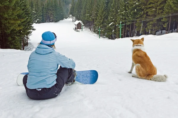 Woman snowboarder with dog — Stock Photo, Image