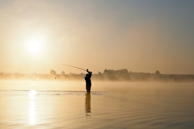 Man Fishing at Dawn clipart