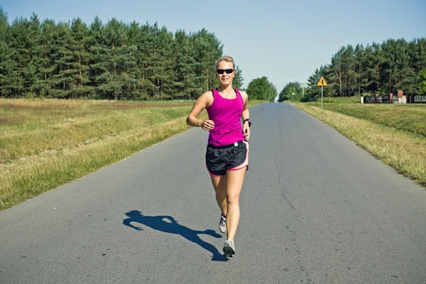 Běžec na silnici赛跑者在乡村道路上 — Stock fotografie