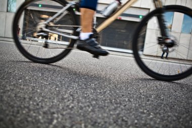 Man cycling on city street clipart