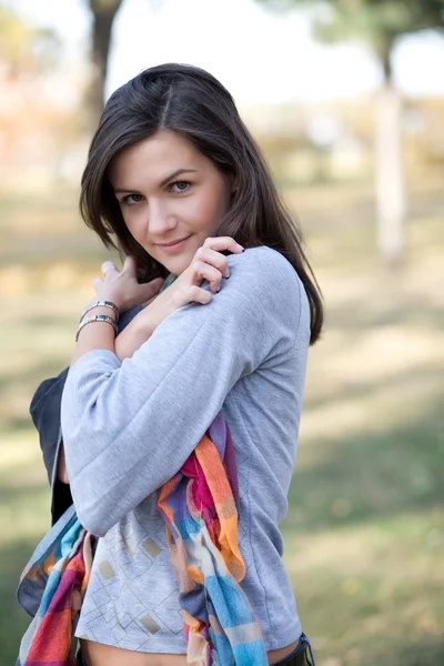 Mladá bruneta v pozadí podzimního parku — Stock fotografie