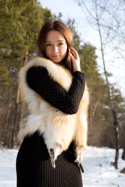 在白雪皑皑的森林里的皮毛背心的年轻女孩 — 图库照片