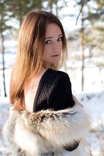 Νεαρό κορίτσι σε ένα γούνινο γιλέκο στο χιονισμένο δάσος — Φωτογραφία Αρχείου