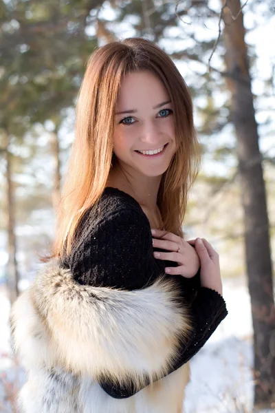 Fiatal lány, a havas erdőben szőrme mellény — Stock Fotó