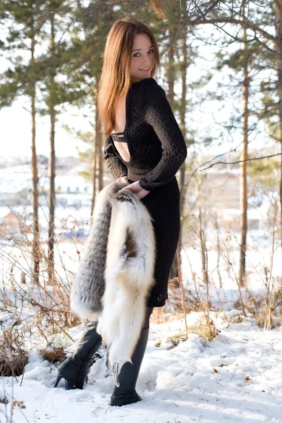 Νεαρό κορίτσι σε ένα γούνινο γιλέκο στο χιονισμένο δάσος — Φωτογραφία Αρχείου